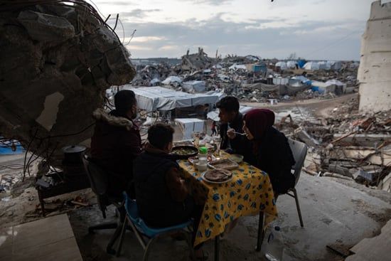 جمع مئات الفلسطينيين، الخميس، لتناول إفطار جماعي في مدينة غزة، على طاولات مؤقتة طويلة وبين أنقاض منازلهم المدمرة (7) جمع مئات الفلسطينيين، الخميس، لتناول إفطار جماعي في مدينة غزة، على طاولات مؤقتة طويلة وبين أنقاض منازلهم المدمرة (7)