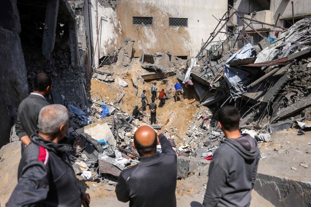 البحث عن ناجين بين أنقاض مبنى دُمر جراء غارة الاحتلال شمال قطاع غزة- أ ف ب