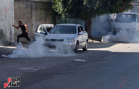 فلسطينى يهرب من قنابل الغاز
