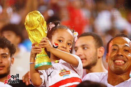 طفلة تحمل كأس العالم
