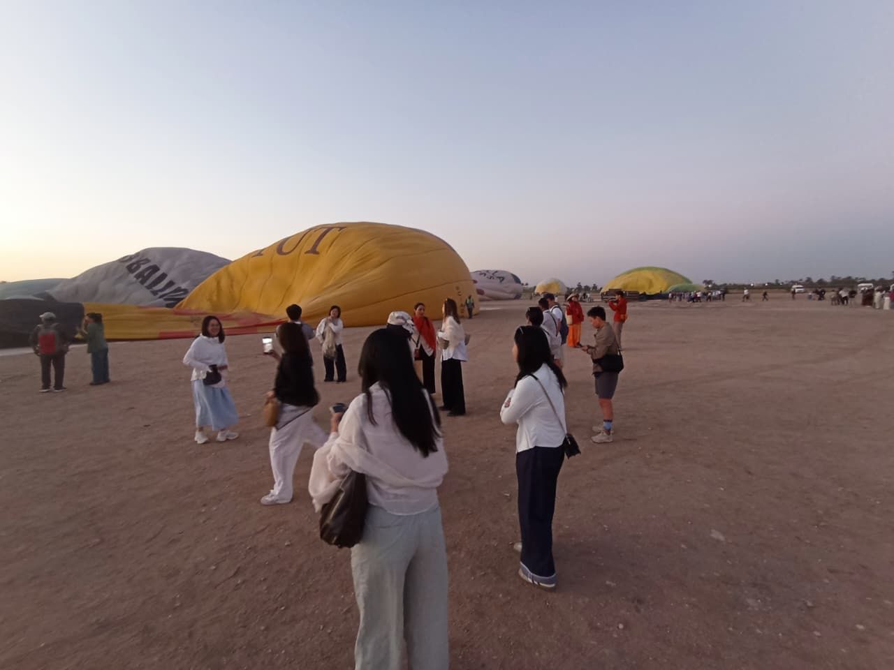 السياح يينتظرون تجهيز البالونات للتحليق بالسماء