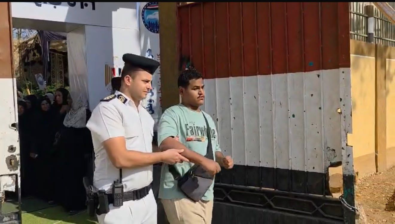 رجل شرطة يساعد كفيف على الادلاء بصوته رجل شرطة يساعد كفيف على الادلاء بصوته