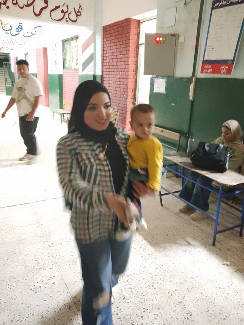 أمراة تحمل طفلها خلال التصويت أمراة تحمل طفلها خلال التصويت