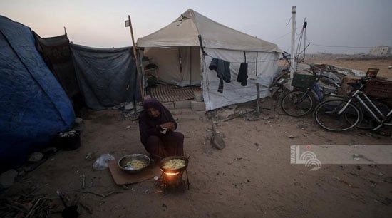 سيدة تطهة الطعام وسط الخيام