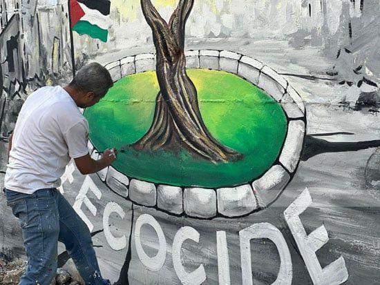 فنان فلسطينى يرسم الجدارية فنان فلسطينى يرسم الجدارية