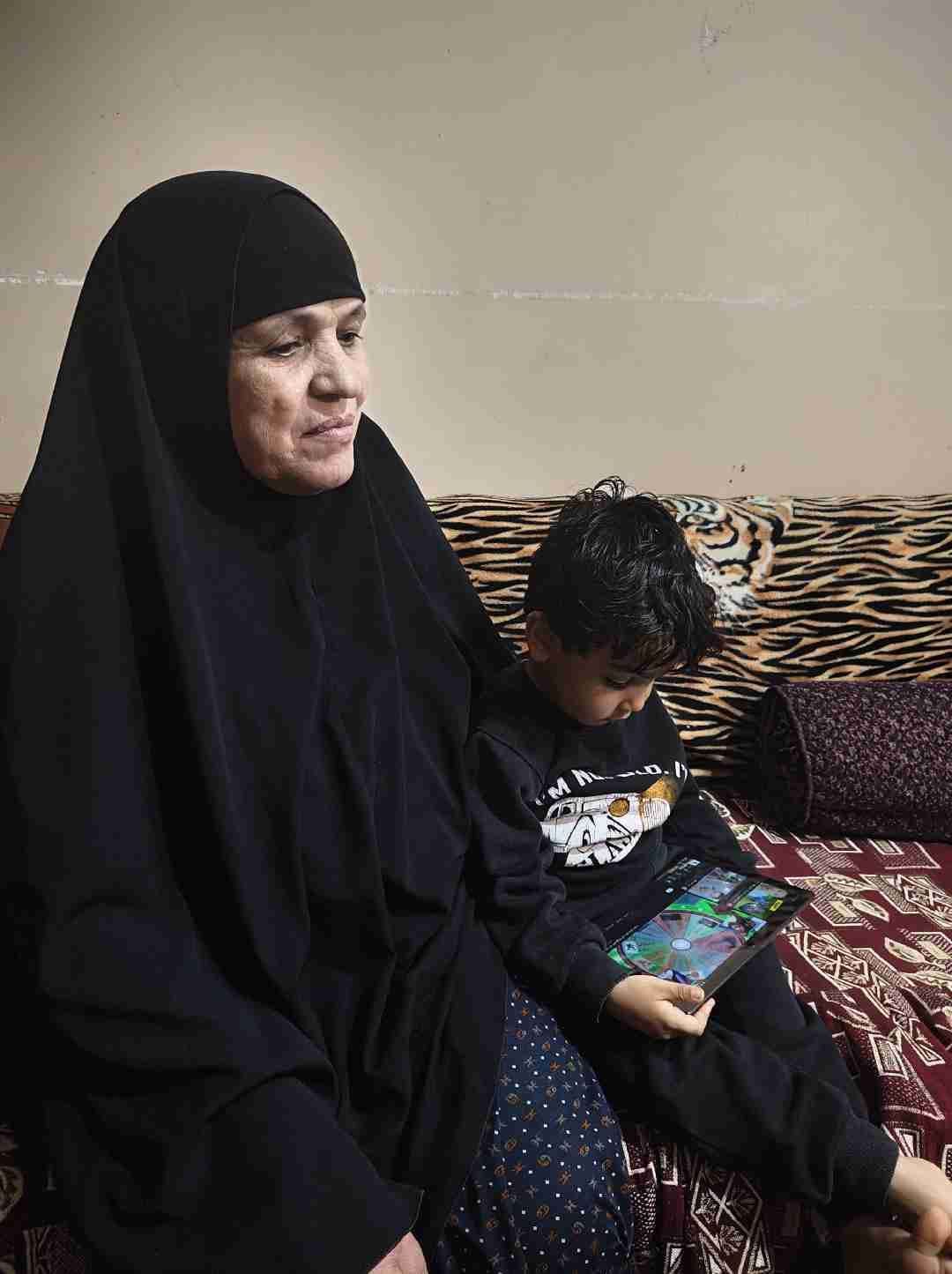 الطفل المصاب مع جدته الطفل المصاب مع جدته