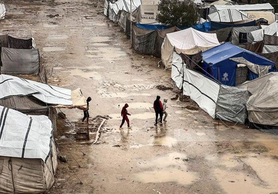 لهوى الأطفال وسط الخيام مع سقوط الأمطار لهوى الأطفال وسط الخيام مع سقوط الأمطار