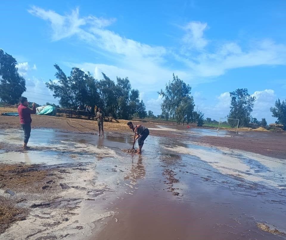 شباب القرية ينزحون المياه من الملعب شباب القرية ينزحون المياه من الملعب