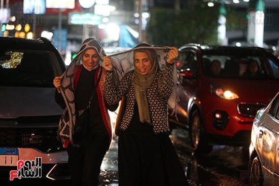 فتيات يغطين رؤسهن تحت المطر فتيات يغطين رؤسهن تحت المطر