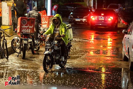 عامل دليفرى يقود دراجته تحت المطر عامل دليفرى يقود دراجته تحت المطر