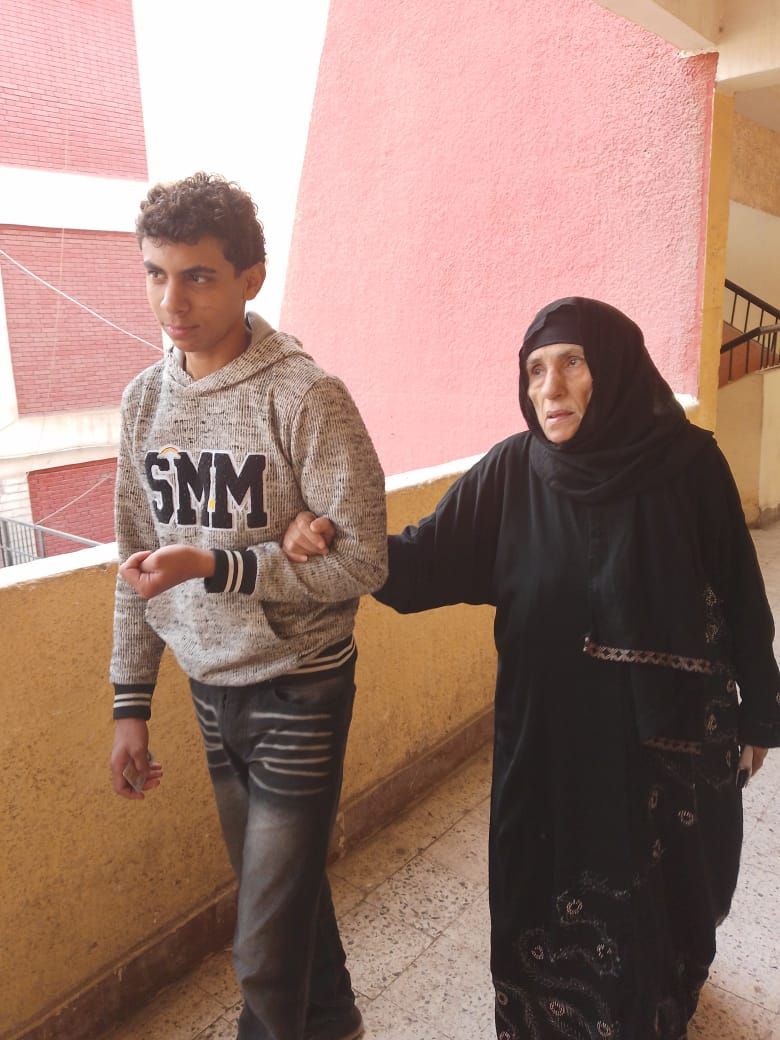 سيدة مسنة تتكئ على حفيدها للتصويت