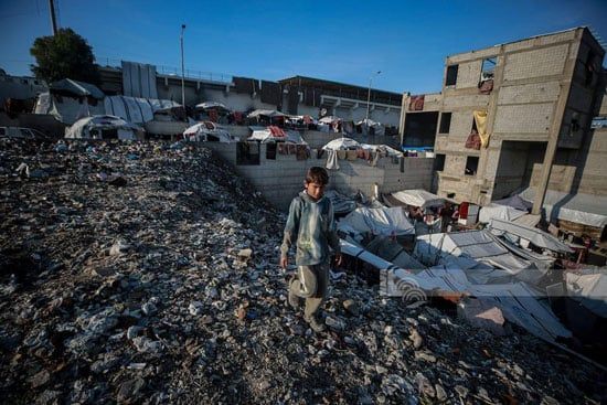 طفل فلسطينى نازح يسير وسط النقايات