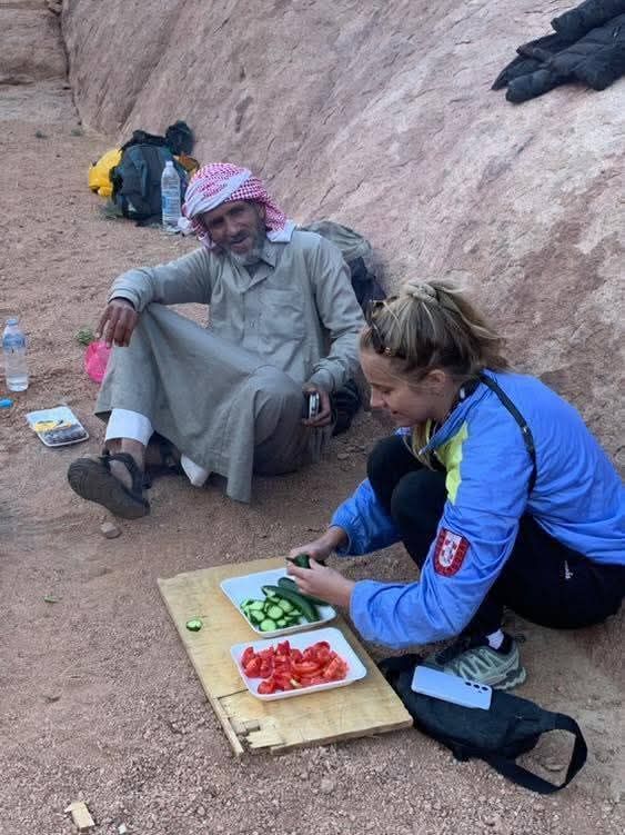 احدى السائحات مع الدليل البدوي أثناء طهى الطعام