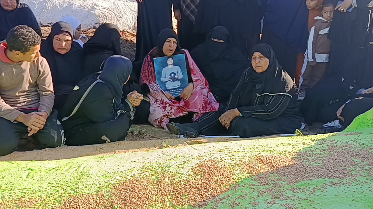 الأم تحمل صورة بالمقابر