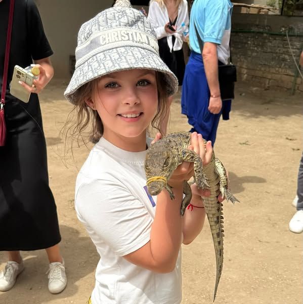 طفلة أجنبية تلهو مع تمساح صغير بجزيرة الموز طفلة أجنبية تلهو مع تمساح صغير بجزيرة الموز