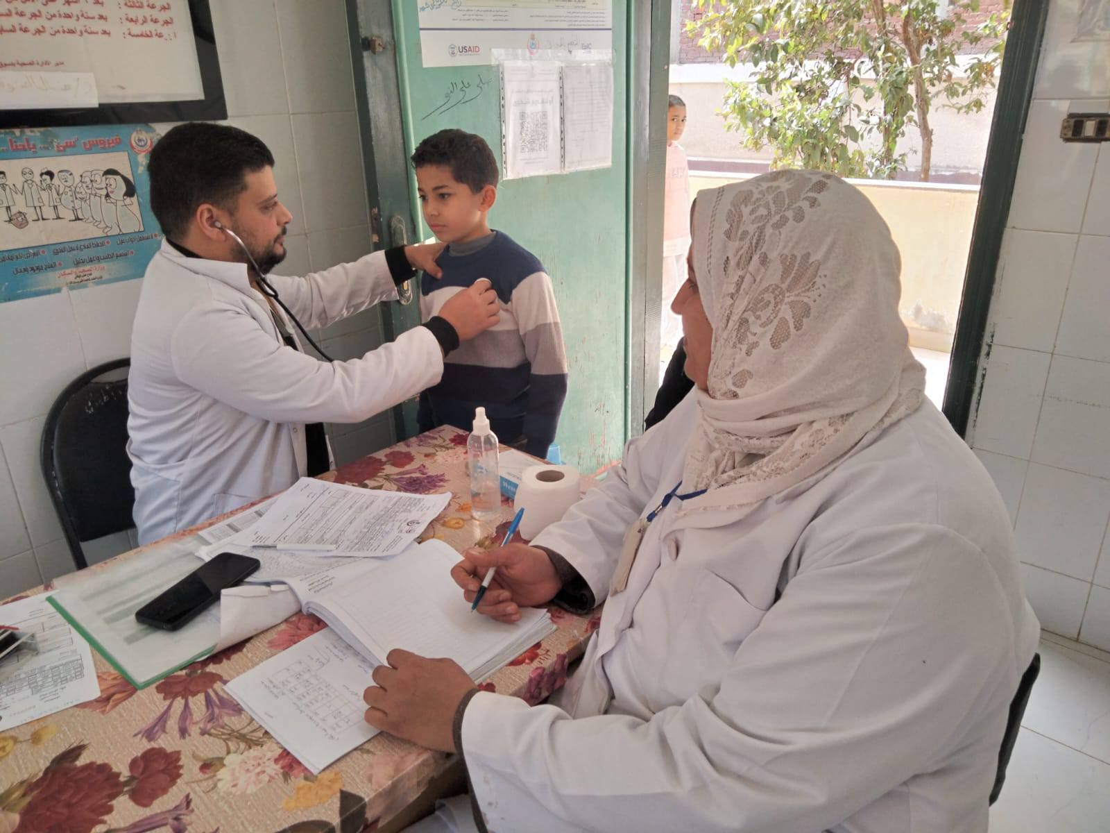 اجراء الكشق الطبي على طفل بالقافلة المجانية اجراء الكشق الطبي على طفل بالقافلة المجانية