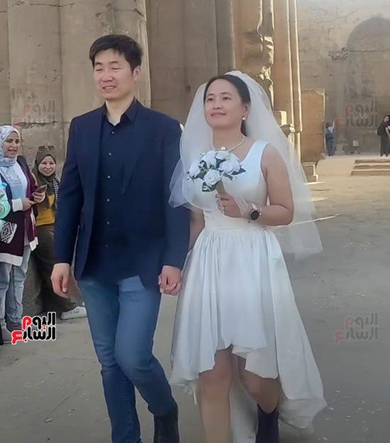سائح-صيني-يحتفل-مع-زوجته-بفستان-وبدلة-الزفاف-في-معبد-الأقصر